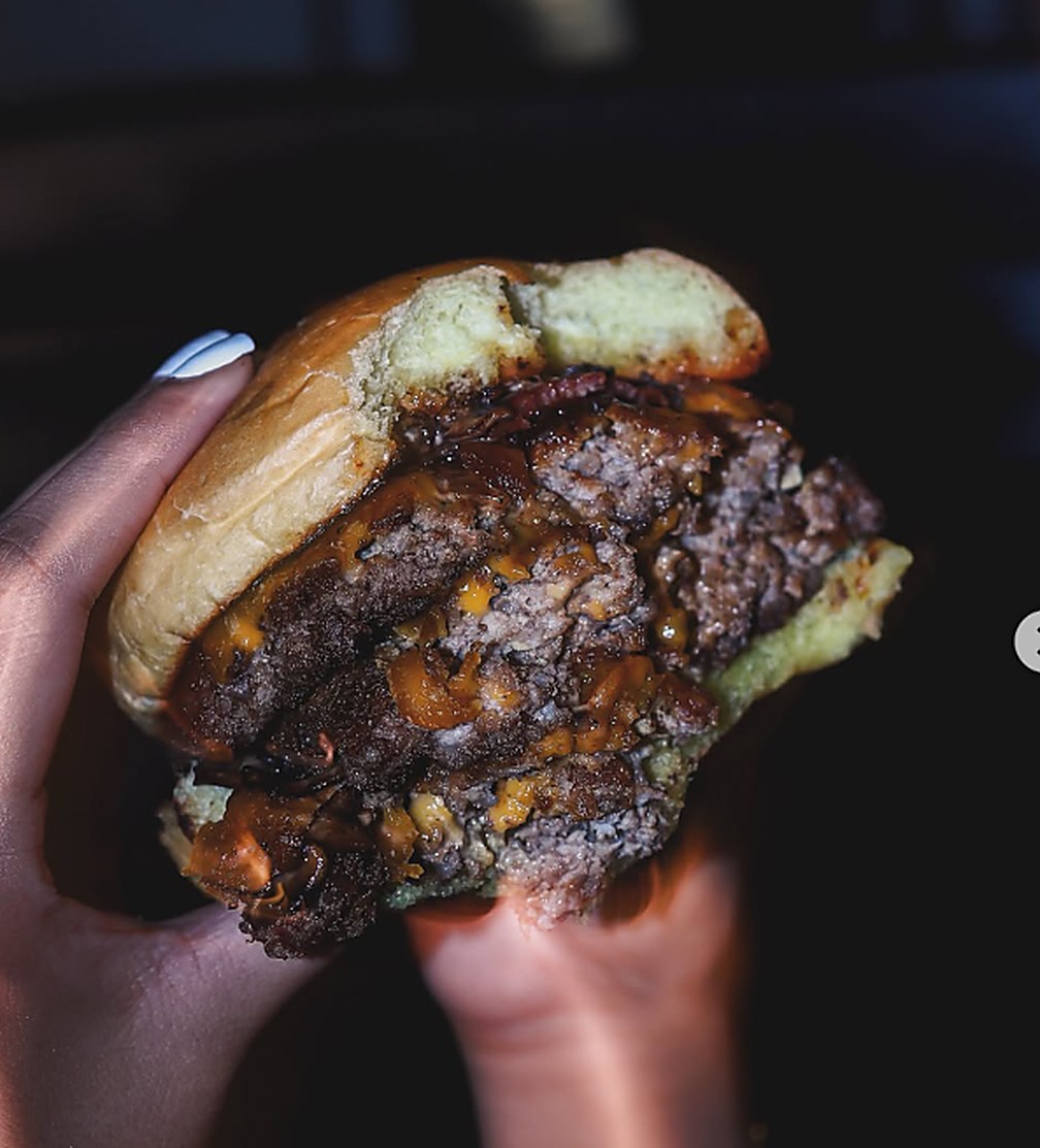 Lorenzo smash burger held in hand